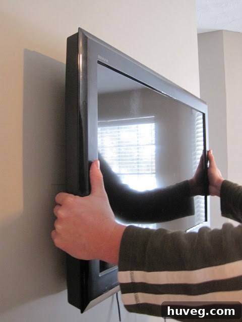 Hooking the TV onto the wall mount