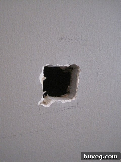 Hole cut into drywall for TV wires