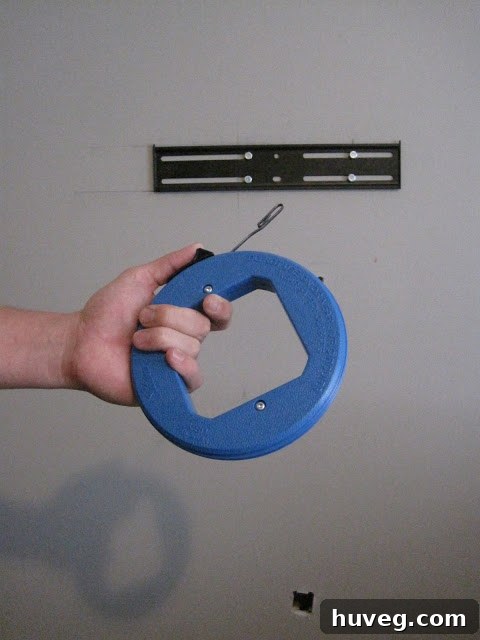 Tool for fishing wire behind drywall, showing its flexibility