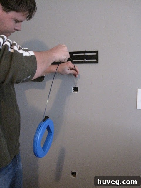 Dropping fish tape into the top hole for wire routing