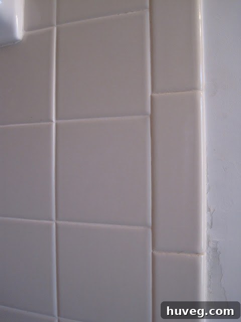 Close-up of the beige-gray builder's tile that will be kept during the bathroom renovation.