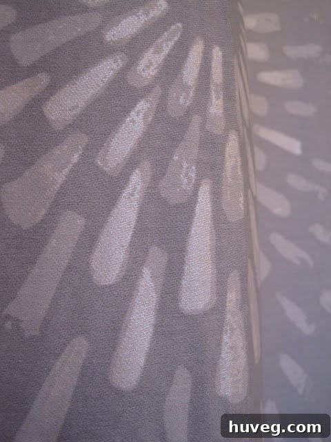 Close-up detail of the new shower curtain, showing its subtle iridescence and sunburst pattern.