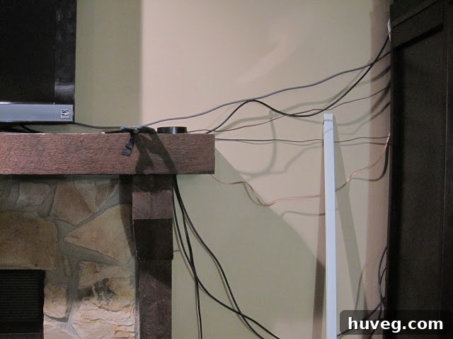 A messy tangle of wires from a home theater setup on the living room floor