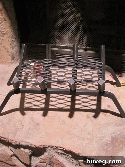 A new fire basket installed in the fireplace, ready to hold logs safely.
