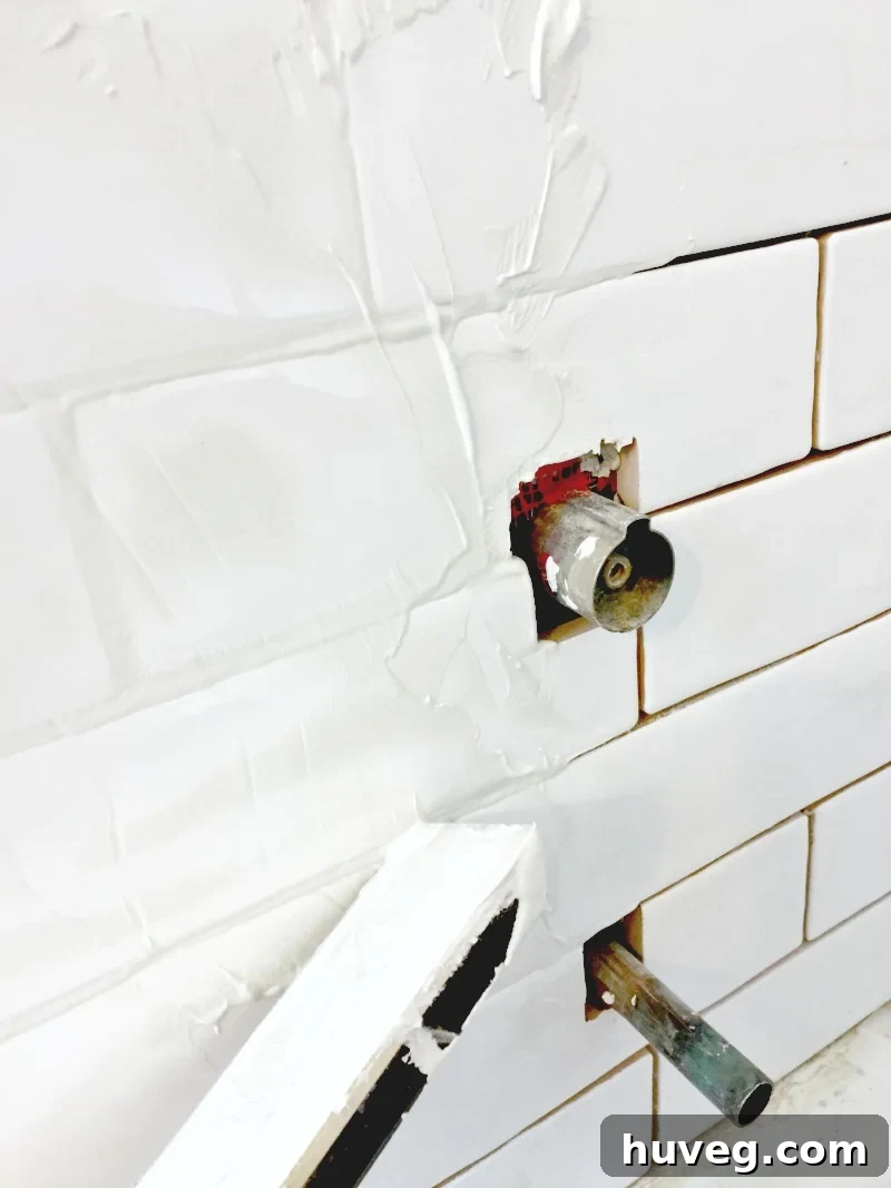 Grouting a bathtub surround with white grout on white subway tile
