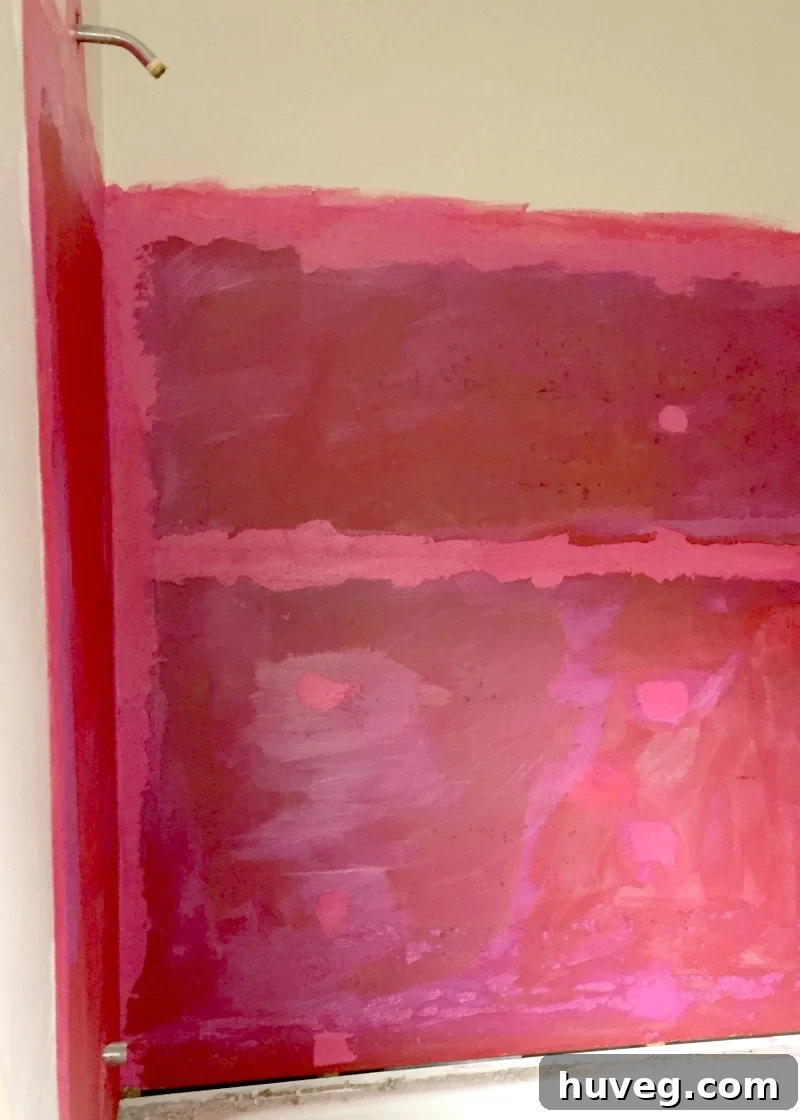 Redgard waterproofing showing color change from pink (wet) to red (dry)