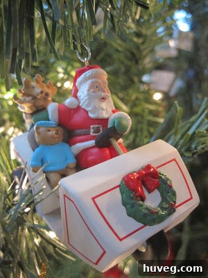 A humorous Hallmark Santa Claus Christmas ornament depicted mid-swing with a golf club, hanging on a festive Christmas tree, reflecting a personal hobby.