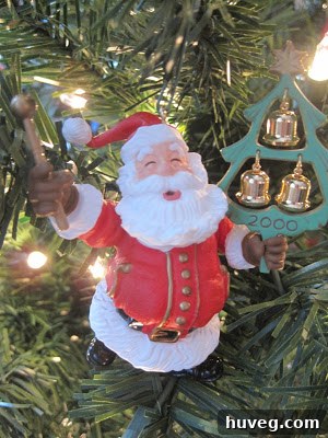 Traditional Christmas bell ornaments that produce a soft jingle when moved, hanging delicately alongside other festive decorations on a lush Christmas tree.