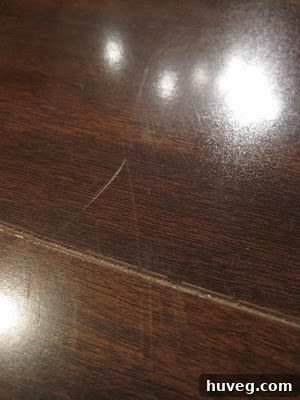 Close-up of a noticeable scratch on a hardwood floor