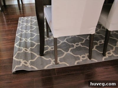 New area rug with noticeable bumps from being rolled up, placed in a dining room