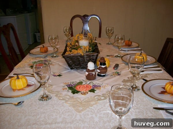 Overhead view of a beautifully set Thanksgiving table with DIY centerpiece and pumpkin place settings