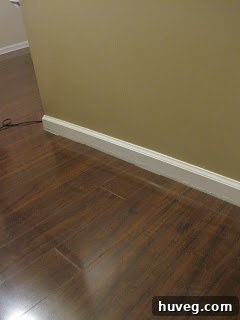 Before shoe molding installation: A view of the floor meeting the baseboard with an visible expansion gap, illustrating an unfinished look.