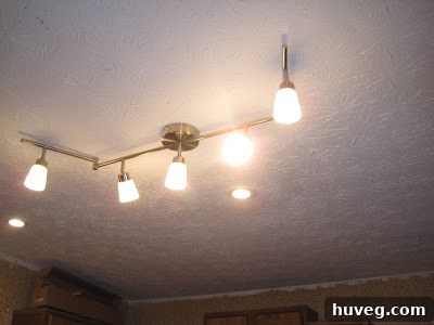 Kitchen interior with new recessed lights and a central IKEA light fixture, showing the renovated space.