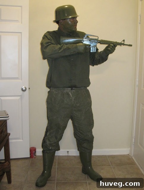 Scott dressed as a homemade green army man, spray-painted entirely green, with a mixing bowl helmet.