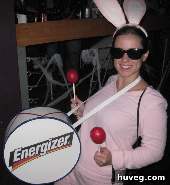 A woman dressed as a homemade Energizer Bunny with a DIY drum, pink ears, and red batons.