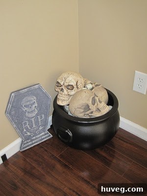 Halloween cauldron filled with decorative skulls in a living room corner