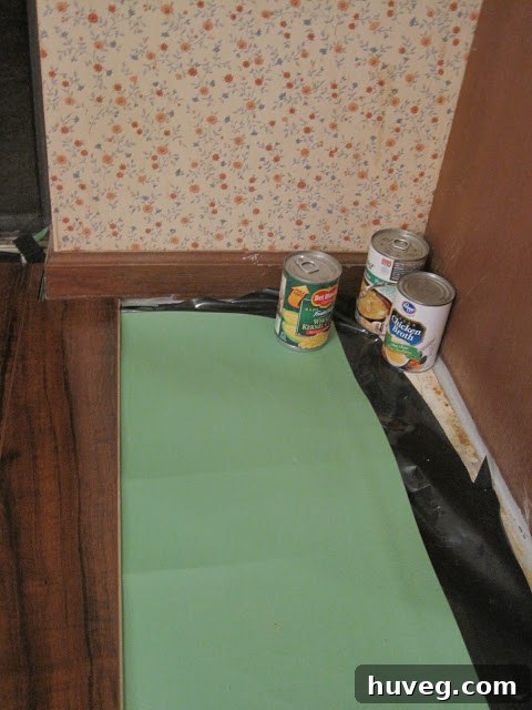 Canned goods used to weigh down underlayment on kitchen floor.