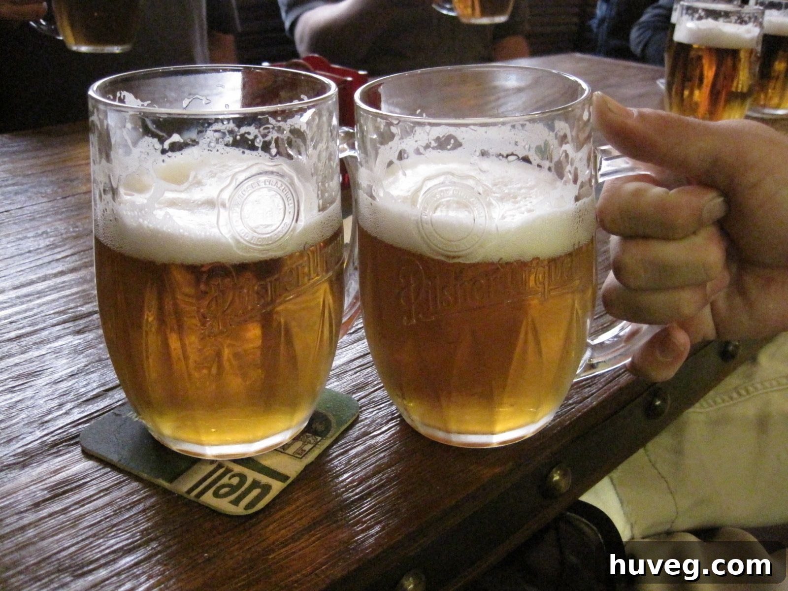 A refreshing glass of 'Pivo,' traditional Czech beer, being enjoyed in a charming local Prague establishment, reflecting the city's rich brewing culture.