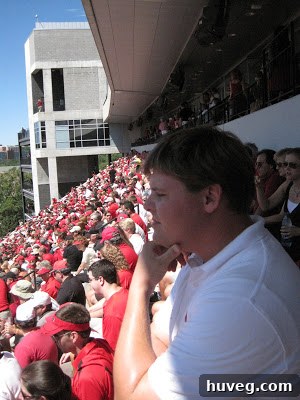 Scott intensely watching the UGA football game, fully absorbed in the action.