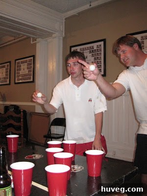 Friends playing a tailgating game, possibly cornhole, during a pre-game celebration.