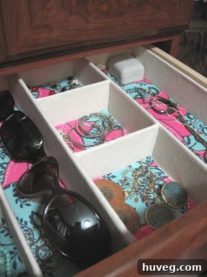 Close-up of neatly organized jewelry in a lined drawer compartment