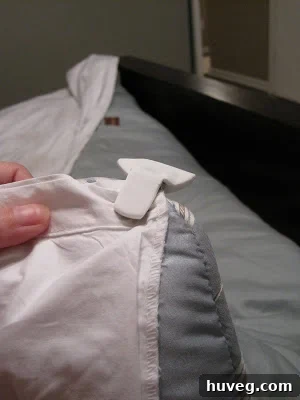 Close-up of a perfectly smoothed duvet cover on a bed, secured by duvet clips.