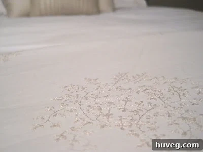 Close-up of the delicate beige floral embroidery on the duvet cover.