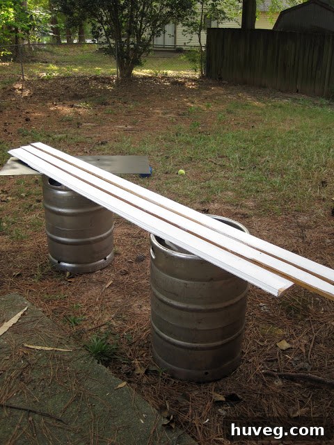 Baseboard trim pieces being painted on sawhorses in preparation for a primary bedroom closet renovation