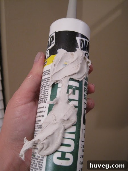 Caulk leaking from a broken tube while inside a caulk gun.