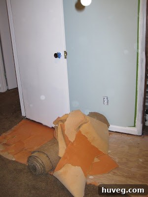 Dusty floor after carpet padding removal, showing dirt accumulated underneath.