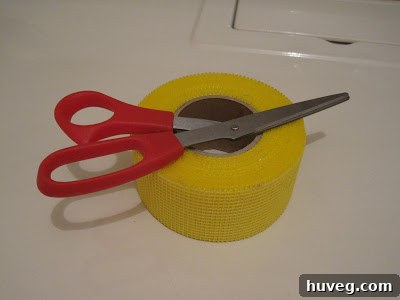 Roll of fiberglass mesh drywall tape, ready for wall repair