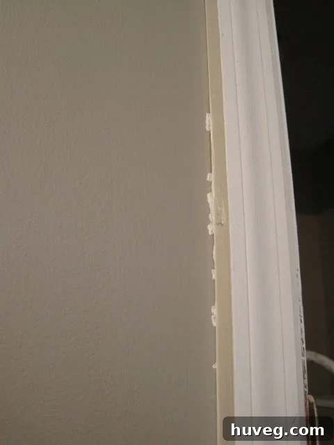 Close-up of a painted trim showing paint bleed and imperfect lines from blue tape