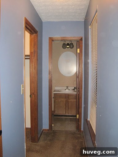Another view of the empty primary bedroom before the makeover, showcasing the original blue color