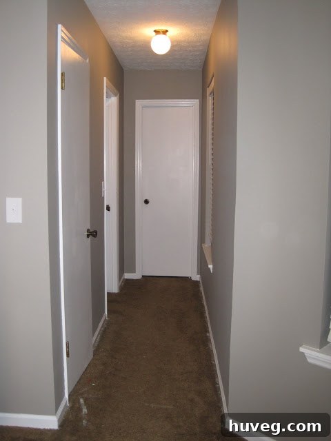Another perspective of the transformed primary bedroom, highlighting the serene gray walls and white accents