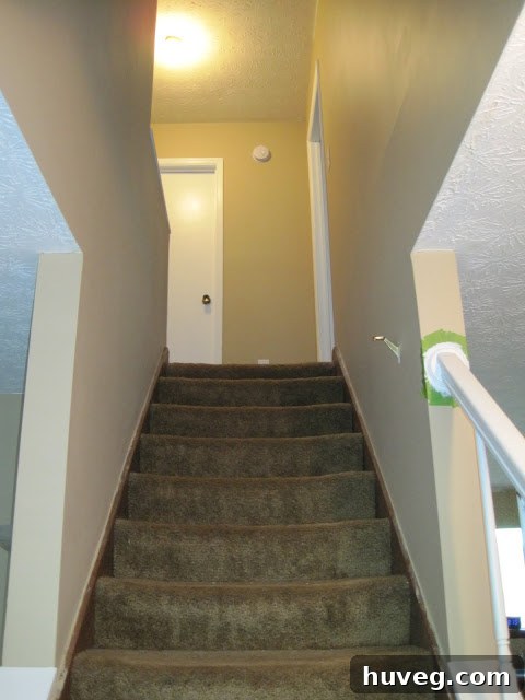 After Hallway: Brighter entryway with updated paint, trim, and new white smoke/carbon monoxide detector