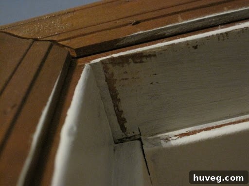 Close-up of a door frame with visible scuff marks from a sticking door, highlighting the problem area before repair.