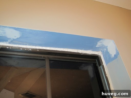 Smoothing freshly applied expanding foam around a window with a paper towel