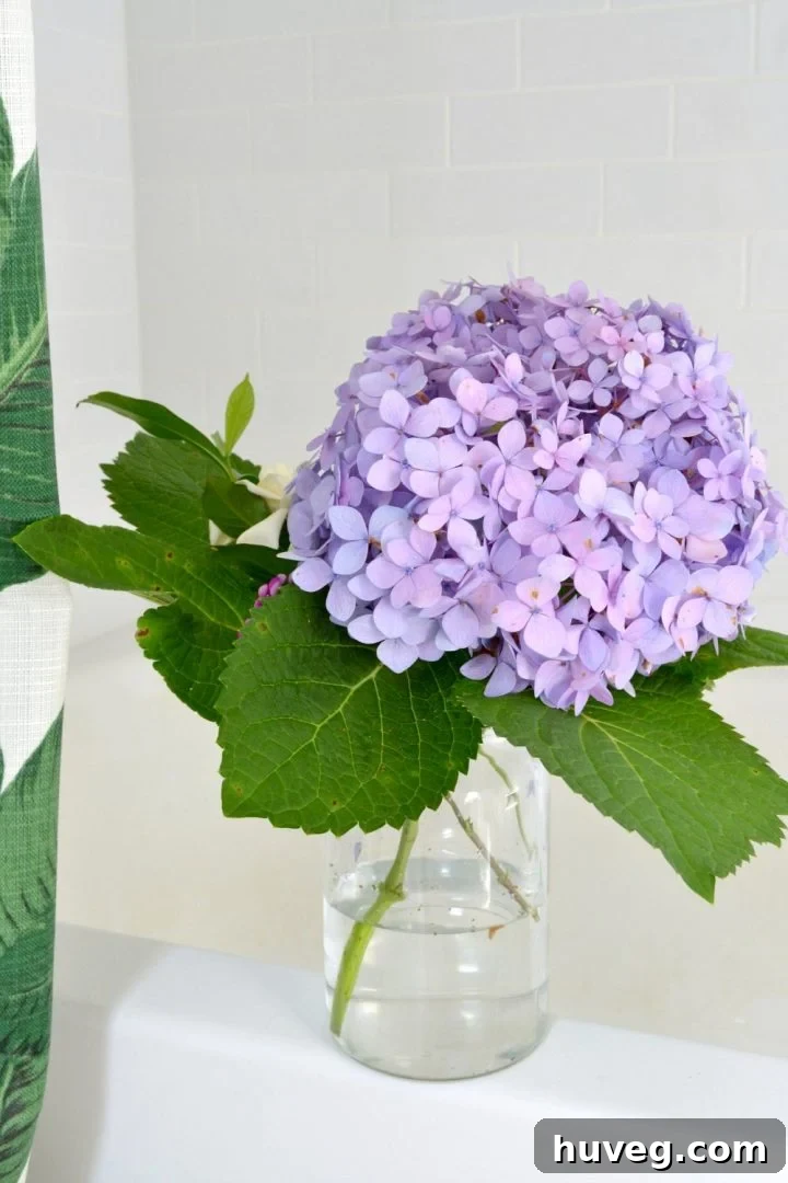 Small, elegant homegrown hydrangea bouquet displayed beautifully in a well-lit modern bathroom setting.