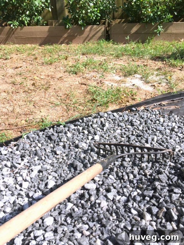 Spreading gravel evenly with a rigid tine rake around the fire pit
