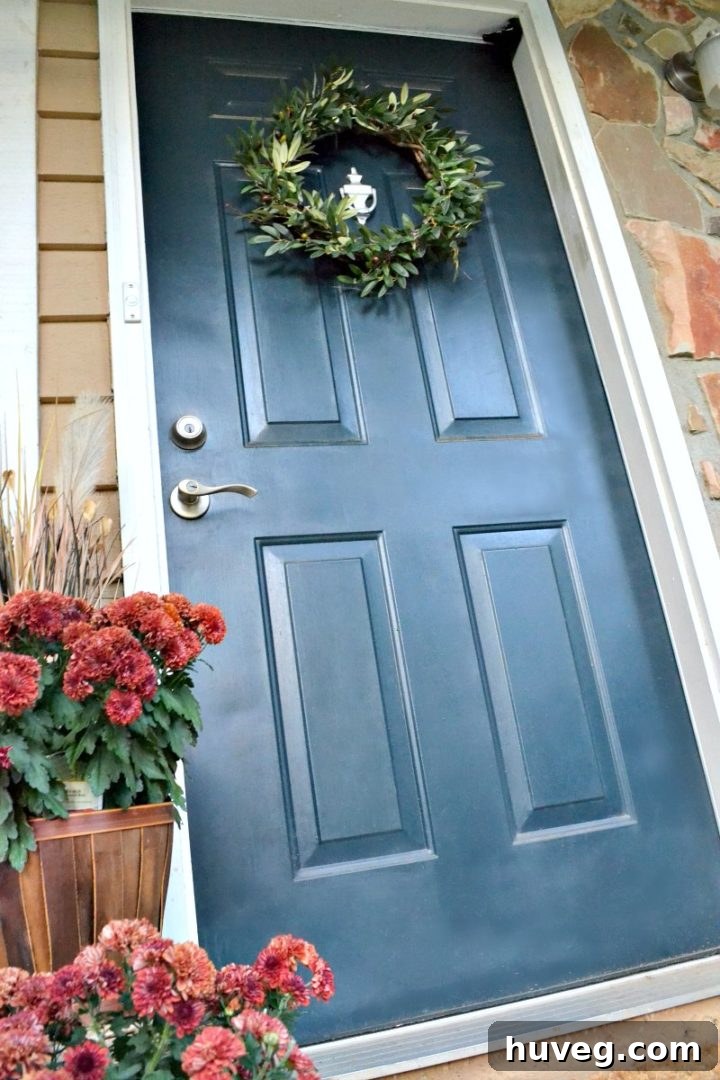 fall front door with new wreath and red mums