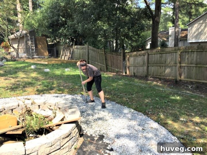 Raking out gravel for the new fire pit area - Backyard Transformation