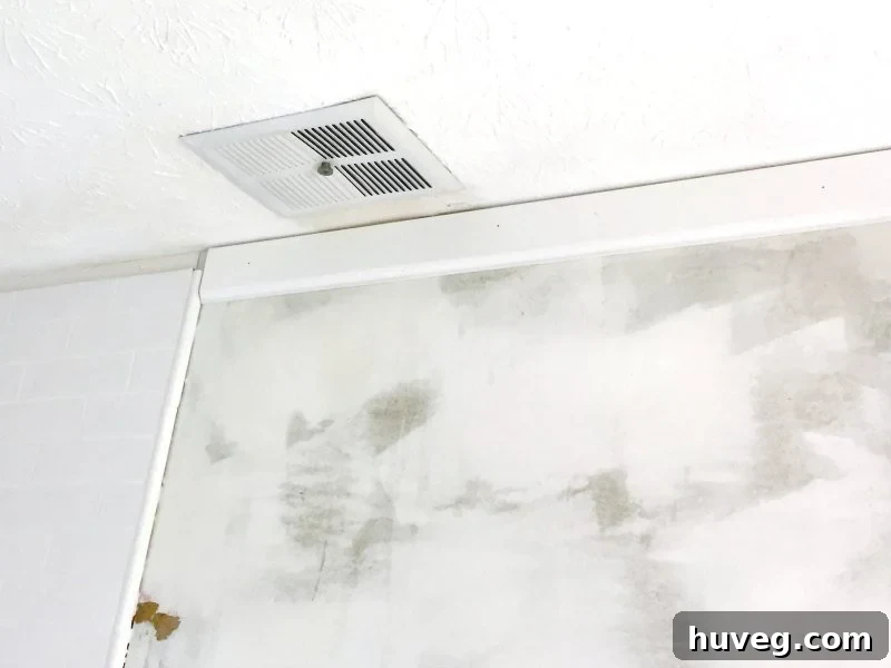 Upside-down baseboard next to tiled shower, preparing for crown molding
