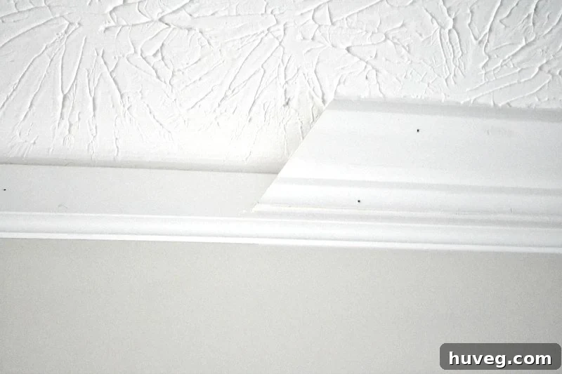 Baseboard installed with crown molding on top, showing the transition