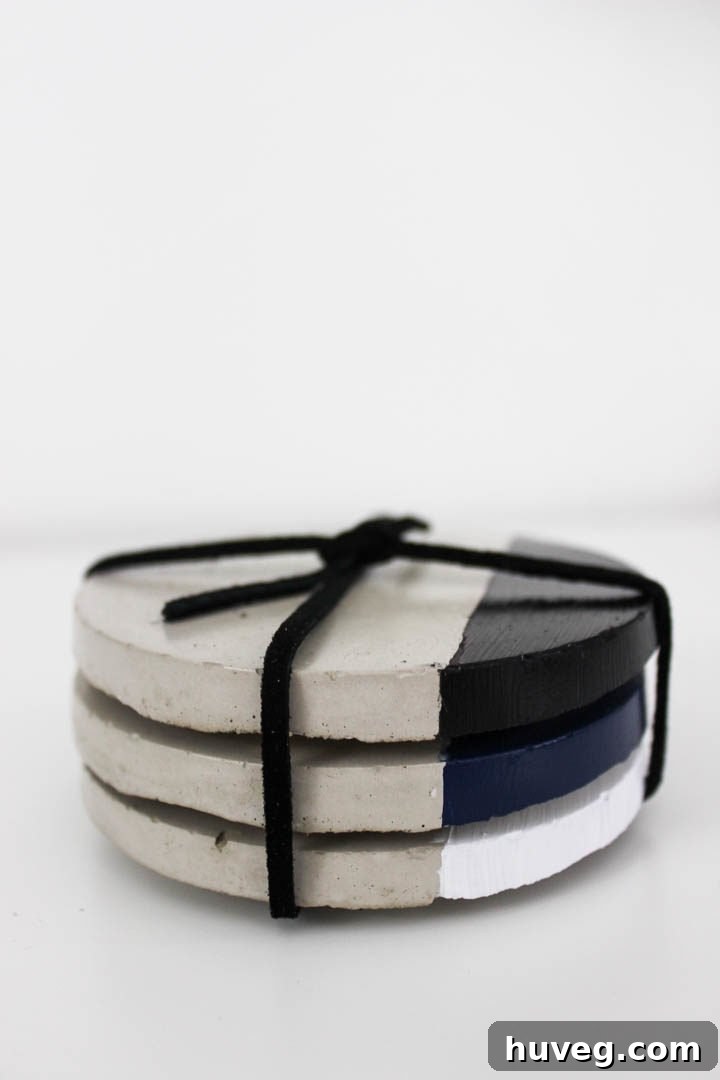 A set of modern concrete coasters with geometric paint details, ideal for home styling.