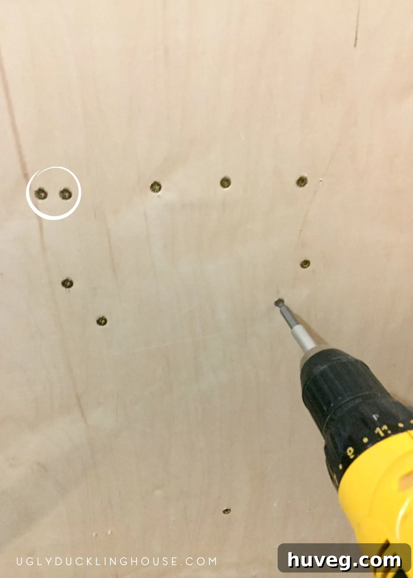 Drilling wood screws into a wine rack support, highlighting the risk of splitting wood