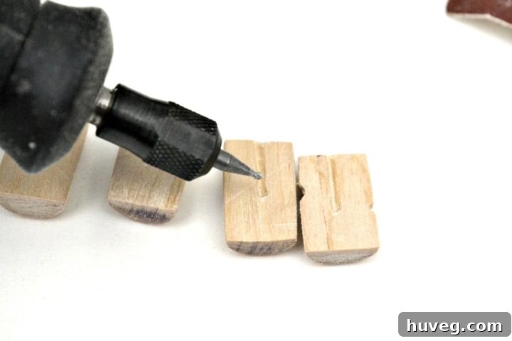 Close-up of a carved wooden charm, showing intricate detail on both sides