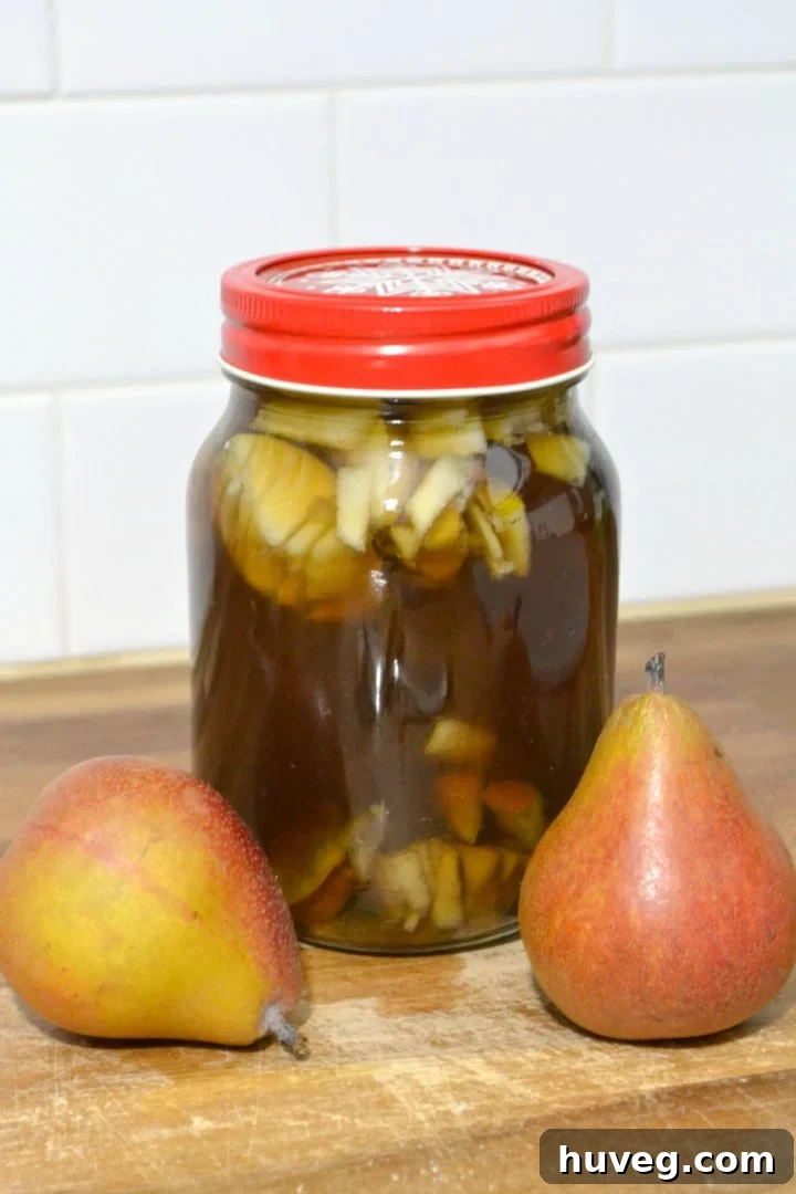 DIY spiced pear and brown sugar liqueur steeping in a mason jar, illustrating the homemade process