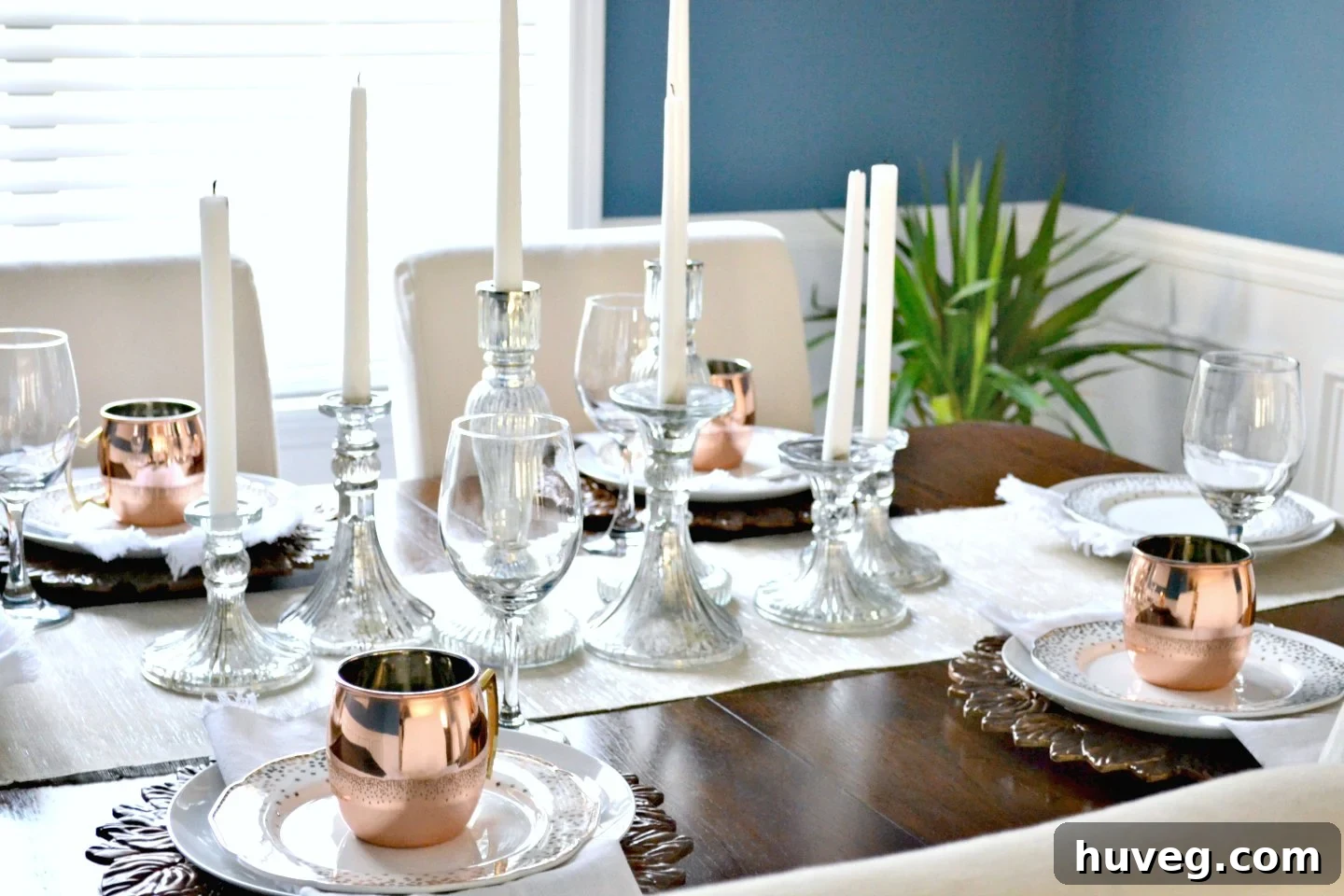 Festive dining room Christmas table setting with shining copper accents and candles