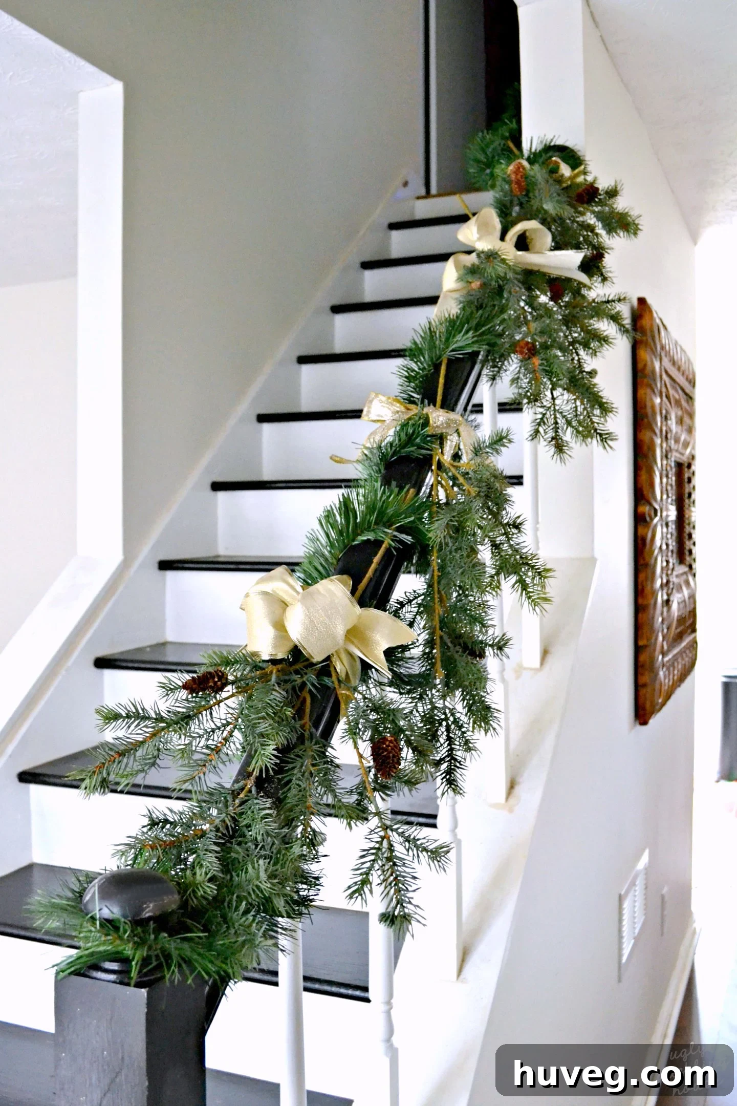 Stunning Christmas staircase featuring elegant gold and green decorations, blending seamlessly with a neutral winter wonderland aesthetic.
