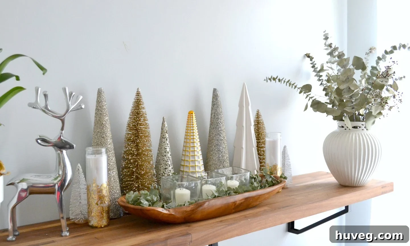 Elegant gold, silver, and white trees arranged on a kitchen bar, creating a sophisticated neutral Christmas display.